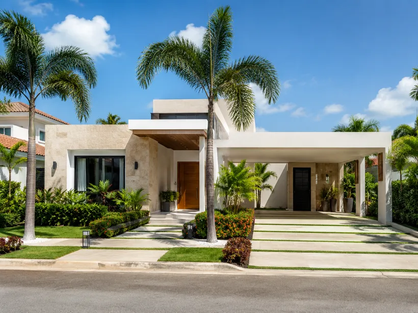 Fachada de una casa familiar moderna con palmeras en República Dominicana.